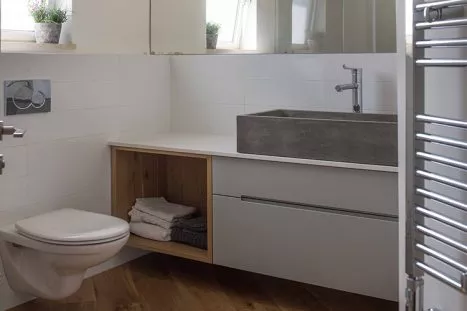 חדר רחצה בהתאמה אישית בסגנון מודרני בצבע לבן ועץ עם כיור בטון
